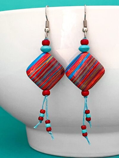 Red, blue and yelllow striped earrings on turquoise waxed cord.