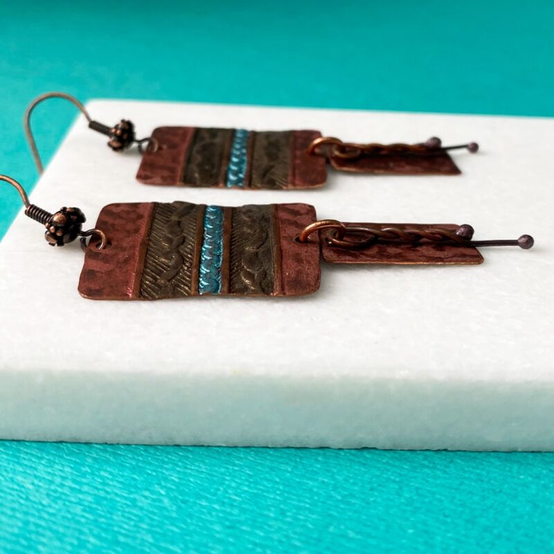 Textured copper components with a turquoise stripe in middle of earring