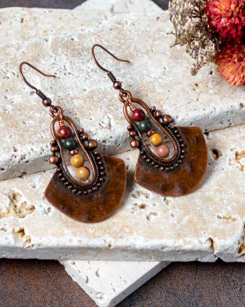 Earrings displayed on stone slab.