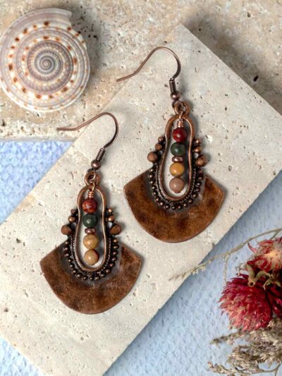 Earrings displayed on stone slab.