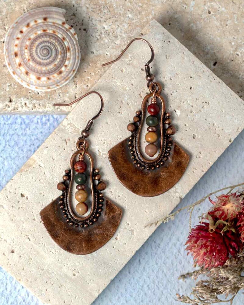 Earrings displayed on stone slab.