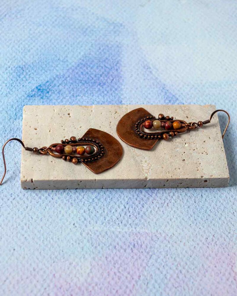 Earrings displayed on stone slab.