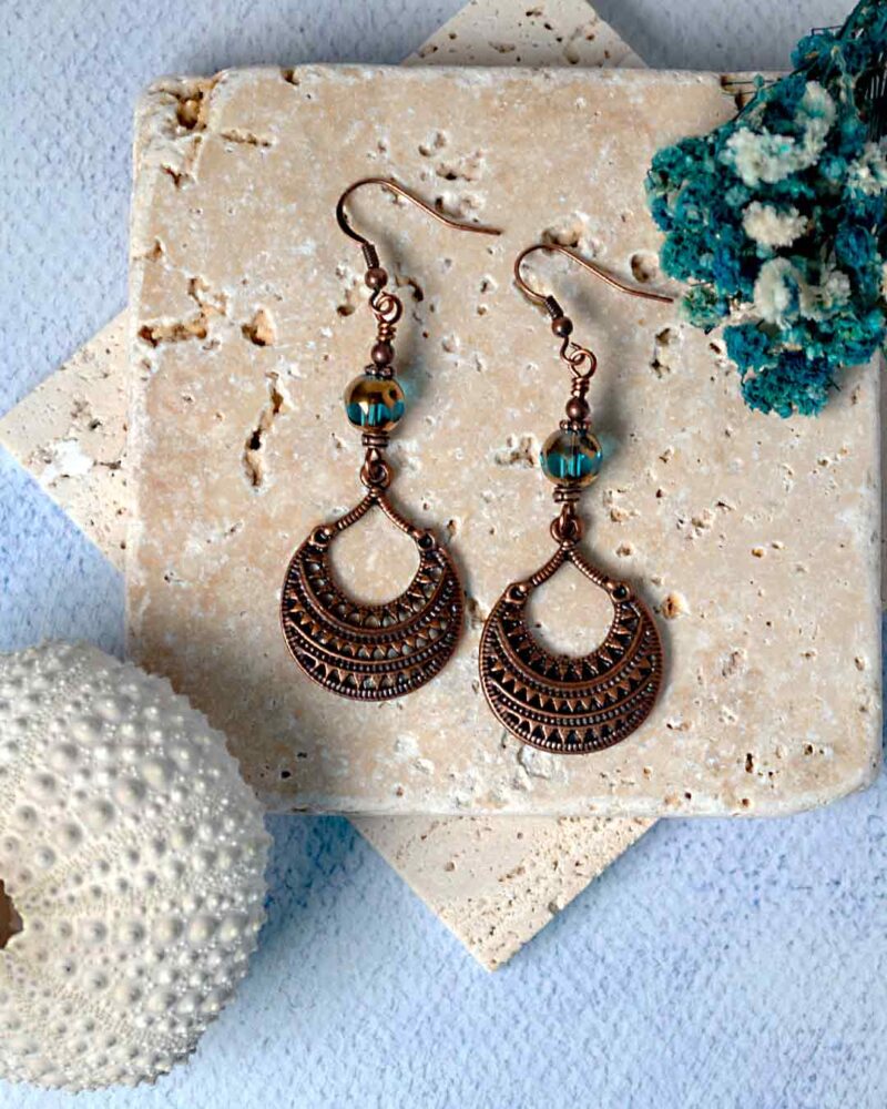 Earrings displayed on stone slab.