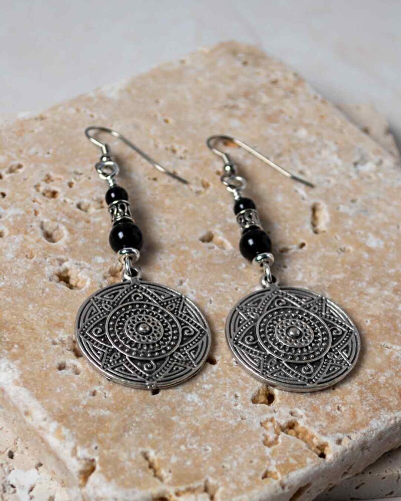 Silver Mandala Earrings displayed on stone slab.